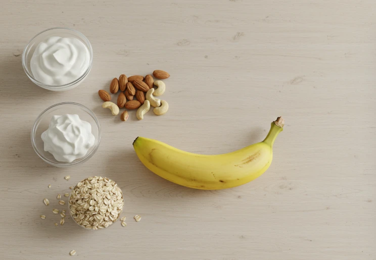 바나나, 요거트, 견과류, 오트밀이 함께 놓인 사진