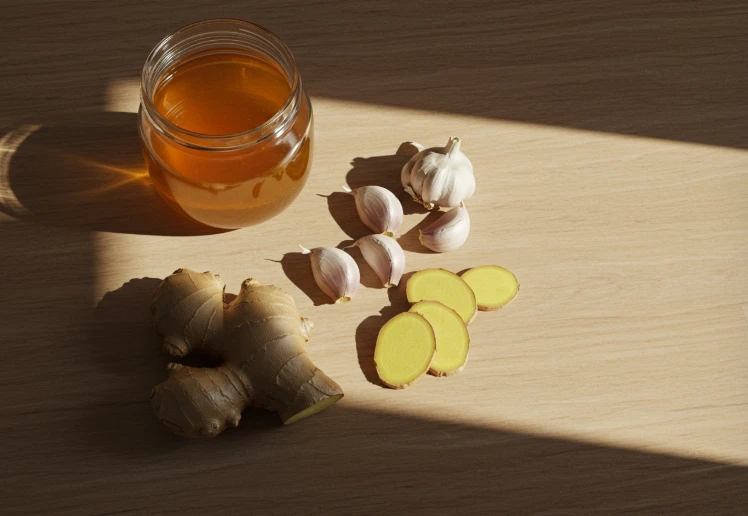 꿀이 담긴 병, 마늘, 생강이 함께 놓인 테이블